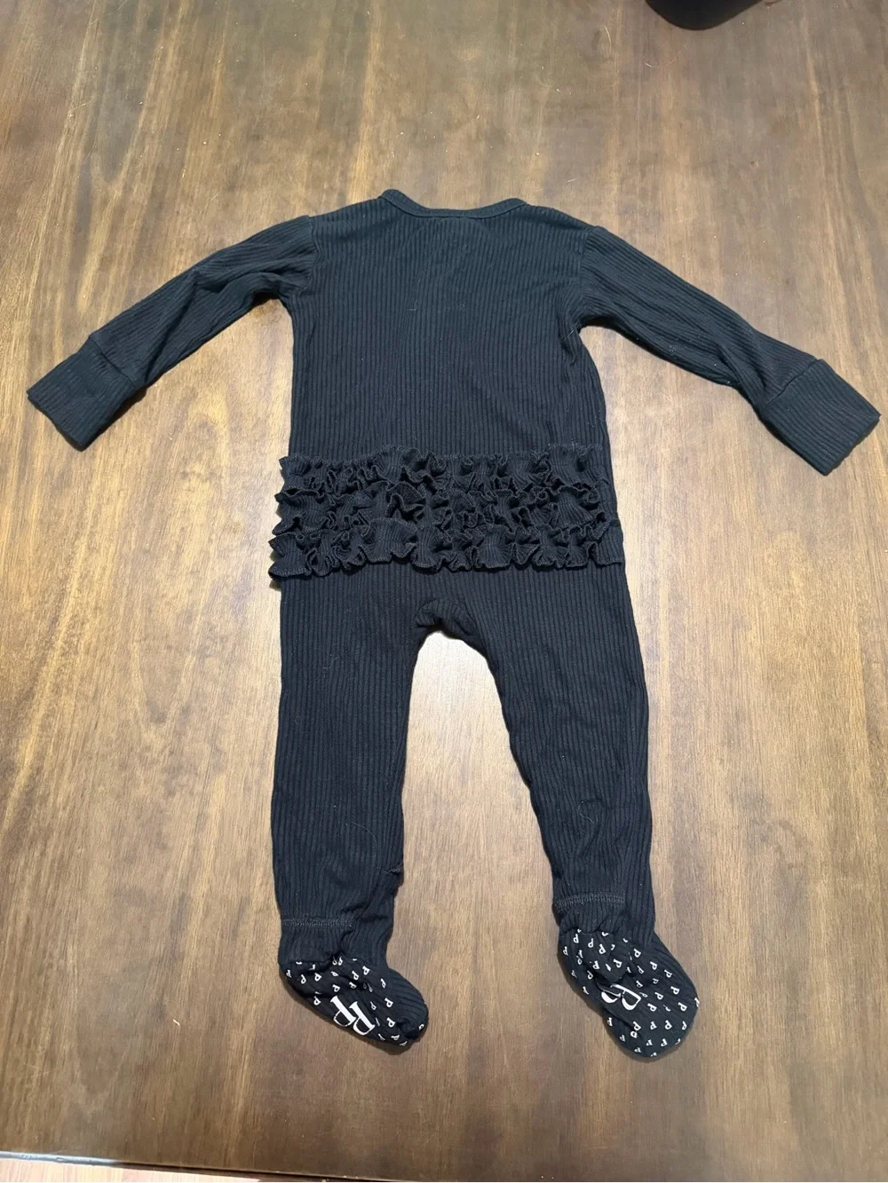 Posh Peanut Black Ribbed Ruffle Footed One-Piece